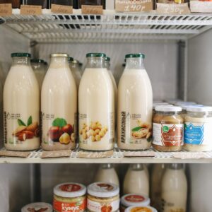 A variety of plant-based milk bottles on display in a refrigerator, showcasing vegan and dairy-free options.