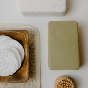 A minimalist flat lay of natural bath products including soap and brushes.