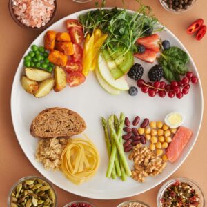 A vibrant assortment of healthy foods on a plate, showcasing a balanced diet with fruits, vegetables, nuts, and grains.